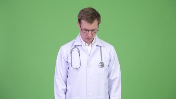 Mann Arzt denkt und schaut nach unten und dreht sich um, um nach oben zu schauen — Stockvideo