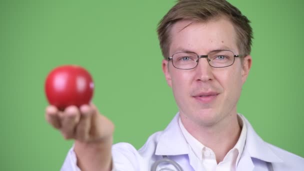 Портрет молодого человека, доктора с красным яблоком — стоковое видео