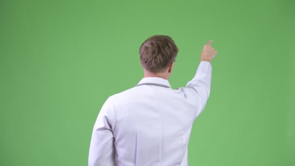 Back View Of Young Man Doctor Turning And Pointing Finger — Stock Video