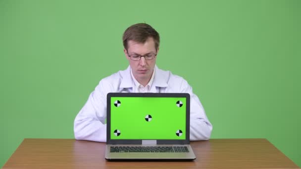 Hombre Doctor Sentado Y Mostrando Chroma Clave Pantalla Verde Ordenador portátil — Vídeos de Stock