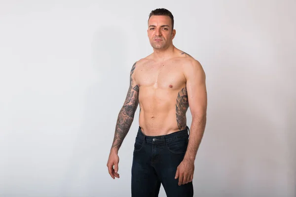 Портрет человека без рубашки с татуировками на белом фоне — стоковое фото