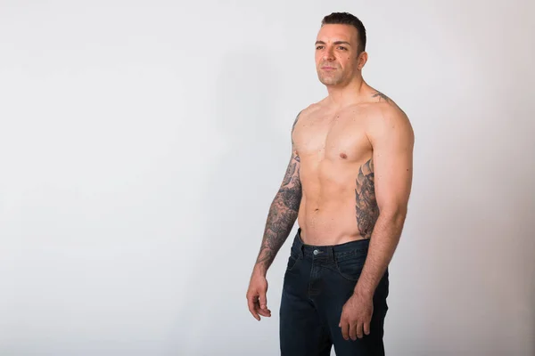 Portret van Shirtless Man met tatoeages tegen witte achtergrond — Stockfoto