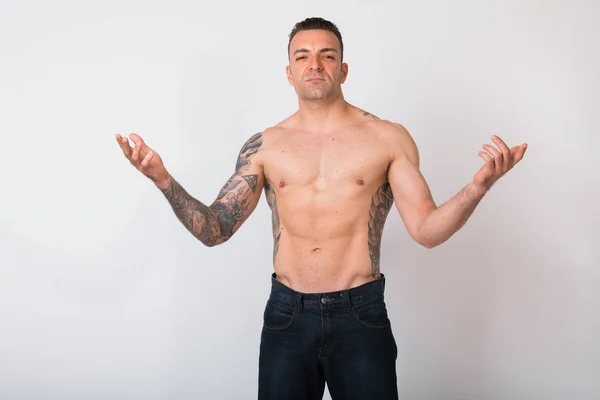 Retrato de hombre sin camisa con tatuajes contra fondo blanco — Foto de Stock