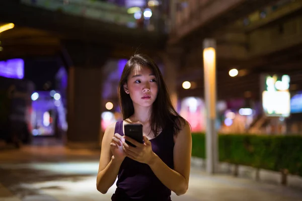 Vacker asiatisk kvinna Utomhus nattetid med hjälp av mobiltelefon — Stockfoto