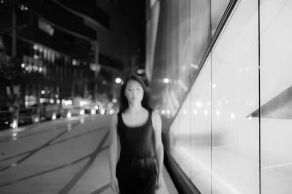Bianco e nero lungo esposizione ritratto con movimento sfocatura di asiatico donna a notte — Foto Stock