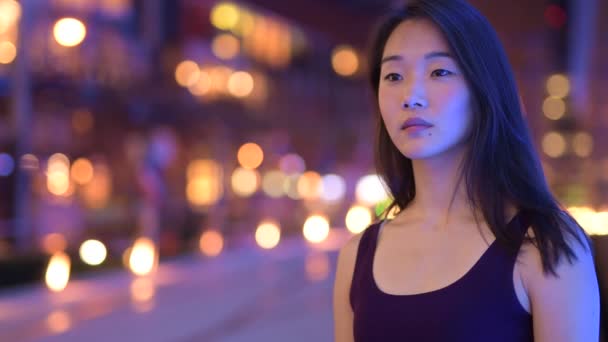 Happy Asian Woman Thinking Outdoors At Night — Stock Video