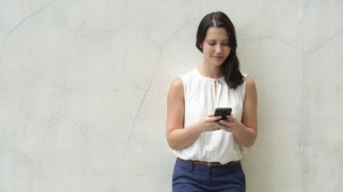Açık havada cep telefonu kullanan güzel genç mutlu kadın portresi