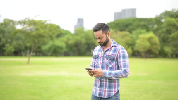 Retrato de joven guapo indio hombre en parque — Vídeos de Stock