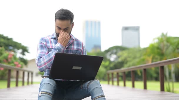 Kostým Indián v parku pomocí přenosného počítače a mobilní telefon — Stock video