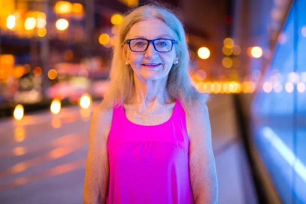 Portrait de femme âgée souriant en plein air la nuit — Photo