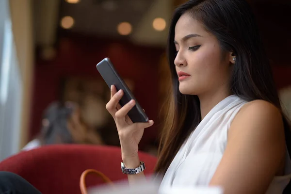 Unga vackra asiatiska affärskvinna avkopplande på coffee shop — Stockfoto