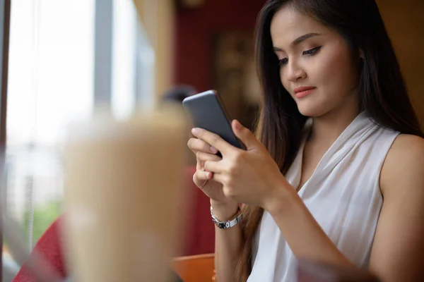 Unga vackra asiatiska affärskvinna avkopplande på coffee shop — Stockfoto