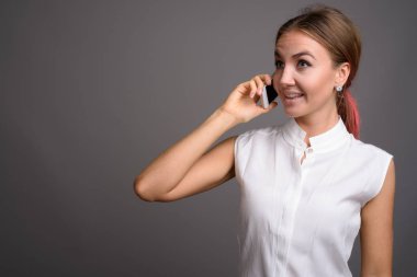 Genç güzel işkadını gri arka plan stüdyo çekim
