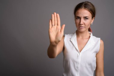 Genç güzel işkadını gri bir arka plana dayanır