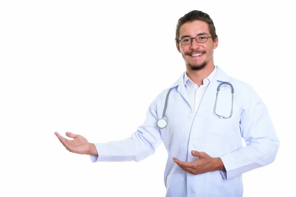 Студійний знімок молодого щасливого лікаря, який посміхається, показуючи деякі — стокове фото