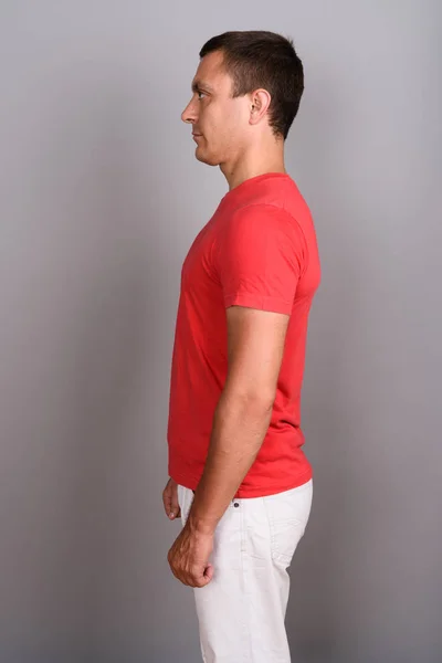 Homem vestindo camisa vermelha contra fundo cinza — Fotografia de Stock