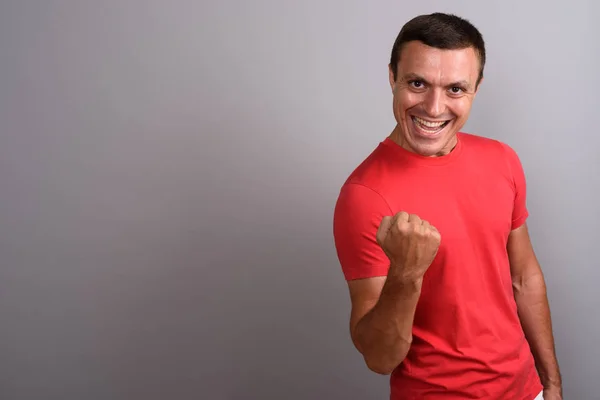 Homem vestindo camisa vermelha contra fundo cinza — Fotografia de Stock