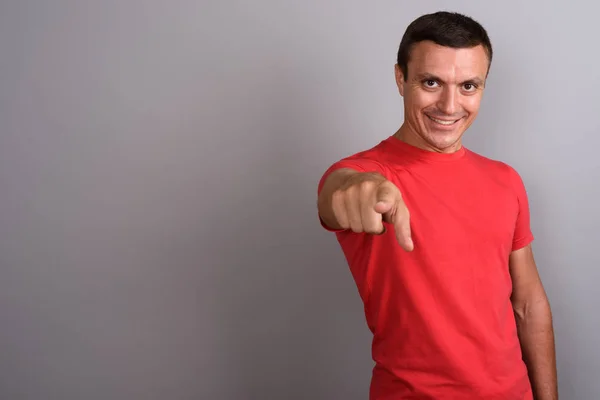 Uomo che indossa camicia rossa contro sfondo grigio — Foto Stock