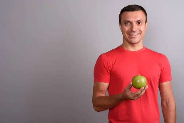 Homem vestindo camisa vermelha contra fundo cinza — Fotografia de Stock