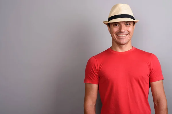 Turystyczna człowiek sobie kapelusz i czerwona koszula szarym tle — Zdjęcie stockowe