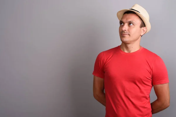 帽子と灰色の背景の赤いシャツを着て観光男 — ストック写真