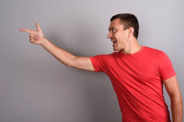 Man wearing red shirt against gray background Stock Photo