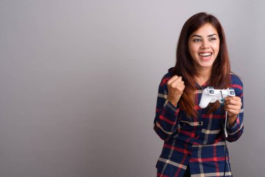 Genç güzel Hintli kadın giyiyor ekose desenli gömlek gri karşı 