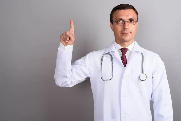 Homem médico vestindo óculos contra fundo cinza — Fotografia de Stock