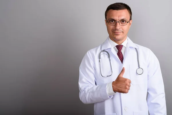 Homem médico vestindo óculos contra fundo cinza — Fotografia de Stock