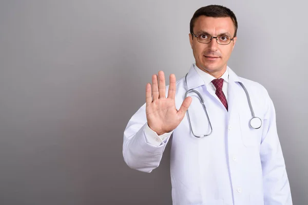 Homem médico vestindo óculos contra fundo cinza — Fotografia de Stock