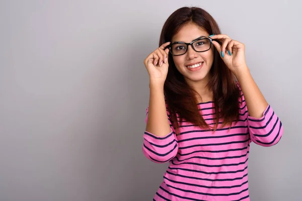 Giovane bella donna indiana che indossa occhiali contro bac grigio — Foto Stock