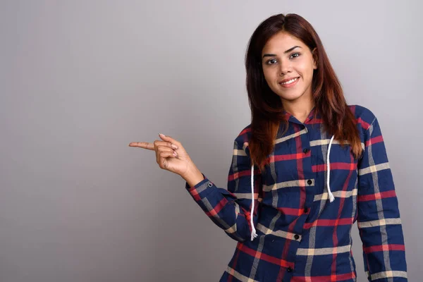 Jovem bela mulher indiana vestindo camiseta verificada contra cinza — Fotografia de Stock