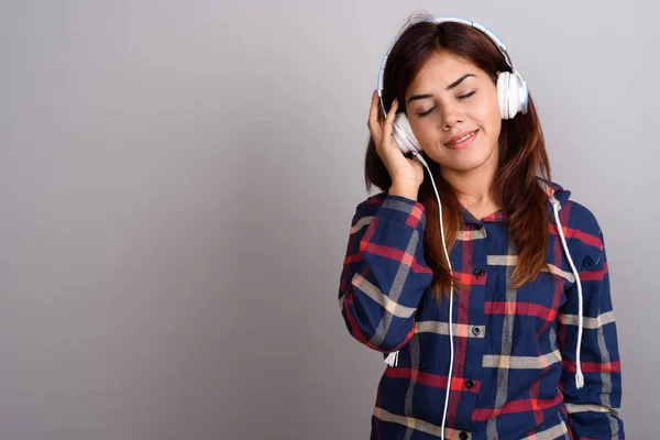 Fiatal gyönyörű indiai nő, hallgató-hoz zene ellen szürke bac — Stock Fotó
