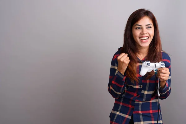 Jovem bela mulher indiana vestindo camiseta verificada contra cinza — Fotografia de Stock