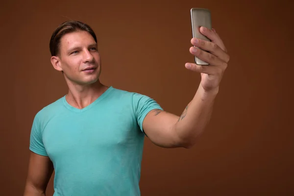 Студийный кадр мускулистого человека на коричневом фоне — стоковое фото