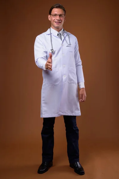 Estudio de hombre médico sobre fondo marrón —  Fotos de Stock