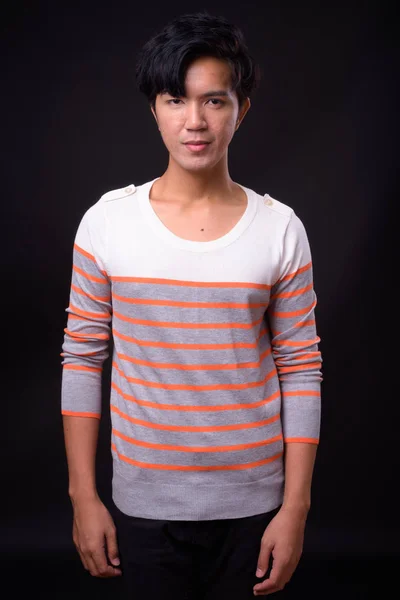 Genç yakışıklı Asya adam siyah arka plan — Stok fotoğraf