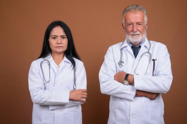 Olgun çok etnik gruptan oluşan çift doktorlar kahverengi zemin karşı