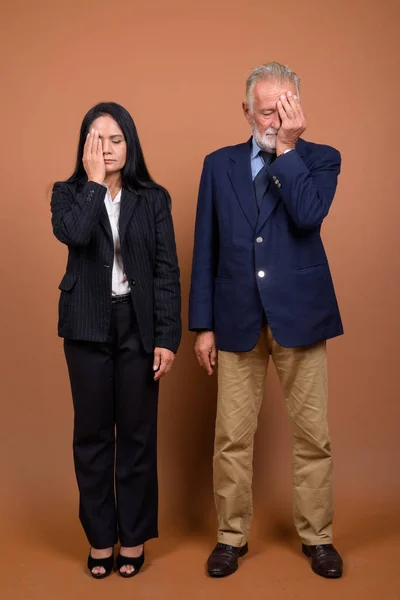 Mature couple d'affaires multi-ethnique sur fond brun — Photo