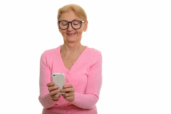 Happy senior nerd woman smiling while using mobile phone — Stock Photo, Image