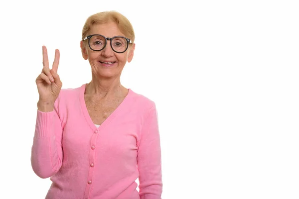Heureuse femme nerd âgée souriante et donnant signe de paix — Photo