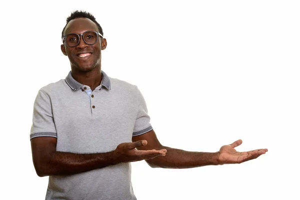 Jovem homem africano feliz sorrindo e mostrando algo — Fotografia de Stock