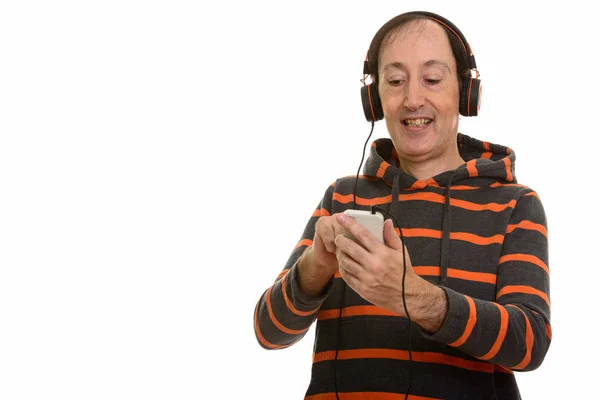 Studio shot van gelukkig volwassen man die lacht tijdens het gebruik van mobiele telefoon — Stockfoto