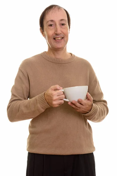 Студийный снимок счастливого взрослого мужчины, улыбающегося, держа чашку кофе — стоковое фото