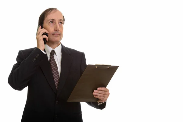 Studioaufnahme eines nachdenklichen, reifen Geschäftsmannes, der auf seinem Handy spricht — Stockfoto