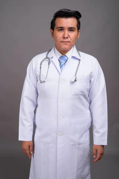 Pemuda multi-etnis dokter terhadap latar belakang abu-abu — Stok Foto