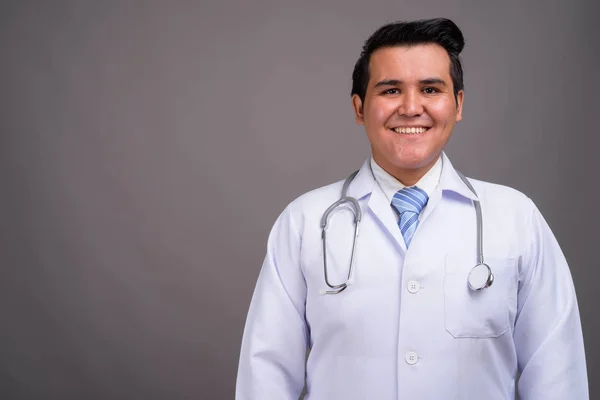 Молодой многонациональный врач на сером фоне — стоковое фото