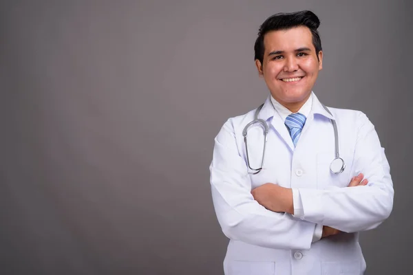 Joven médico hombre multiétnico contra el fondo gris —  Fotos de Stock