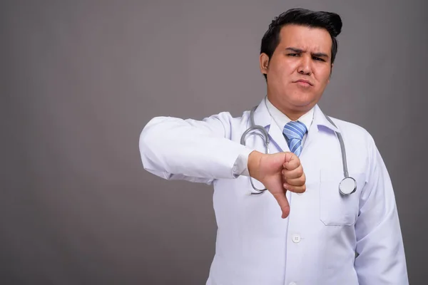 Молодий багатоетнічний лікар на сірому фоні — стокове фото