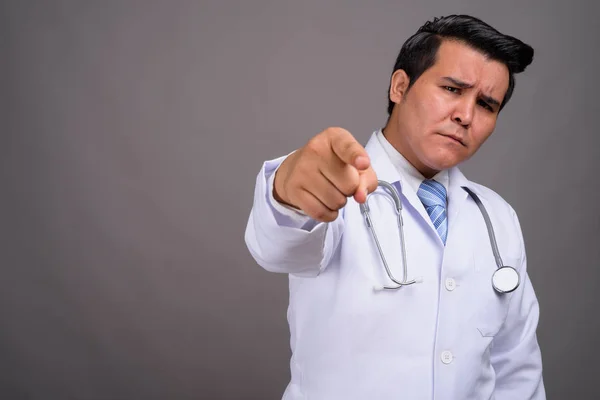 Young multi-ethnic man doctor against gray background — Stock Photo, Image